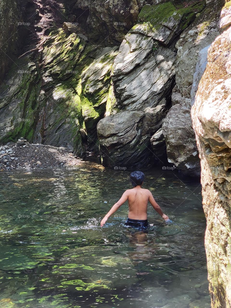 kid wading in water during summer