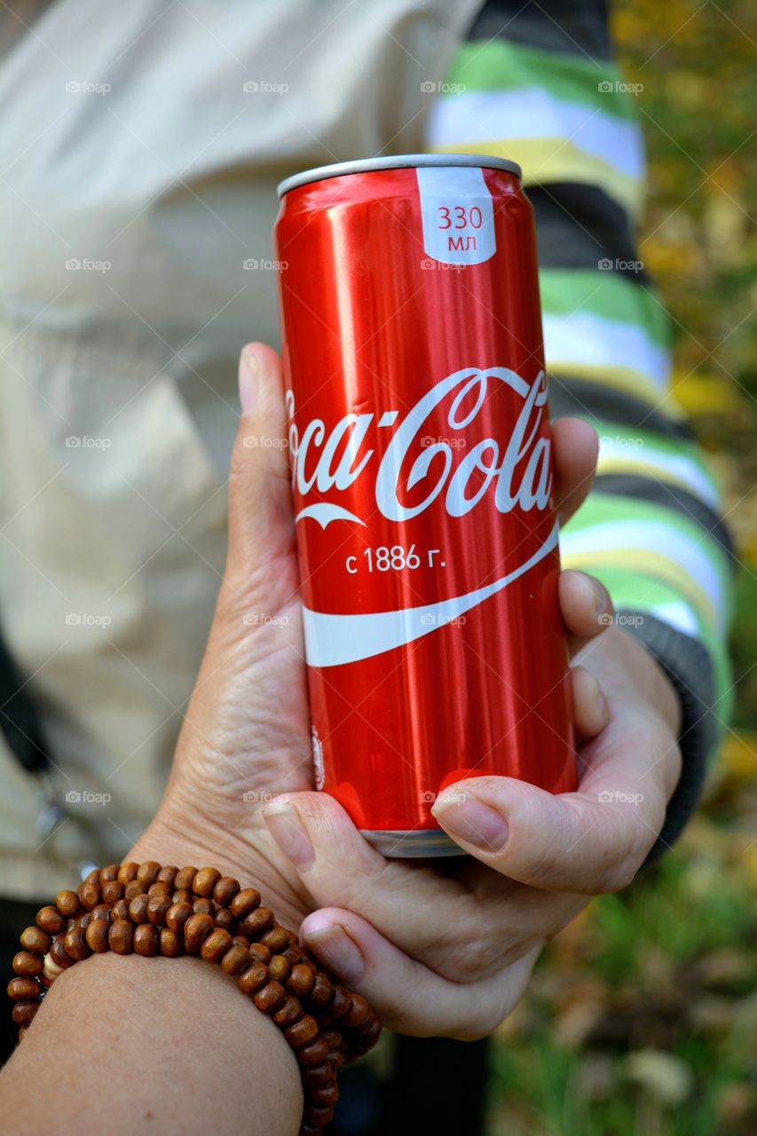 coca cola in the hands outdoor beautiful  background