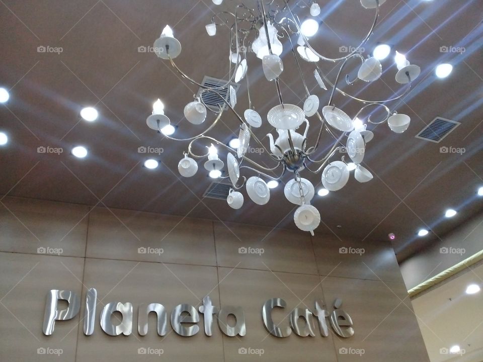 Chandelier with dish, cups and teapot. Coffe shop "Planeta Café"