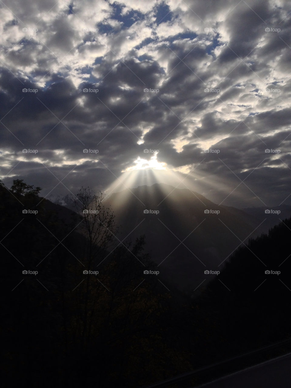 sun through clouds at 6 pm by swisstraveler