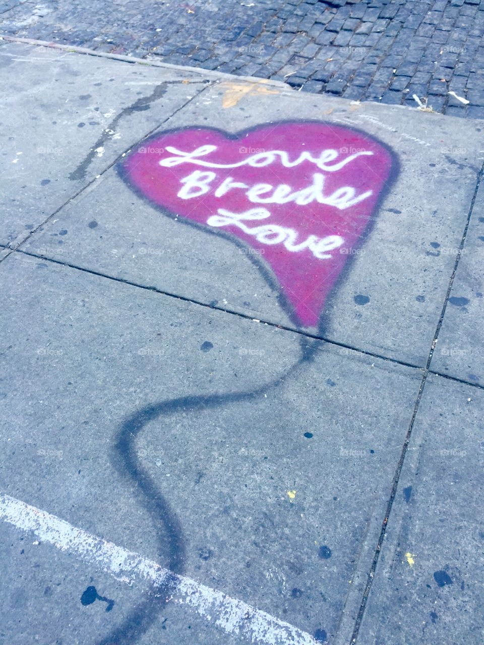 Love breeds love graffiti on sidewalk in NYC 
