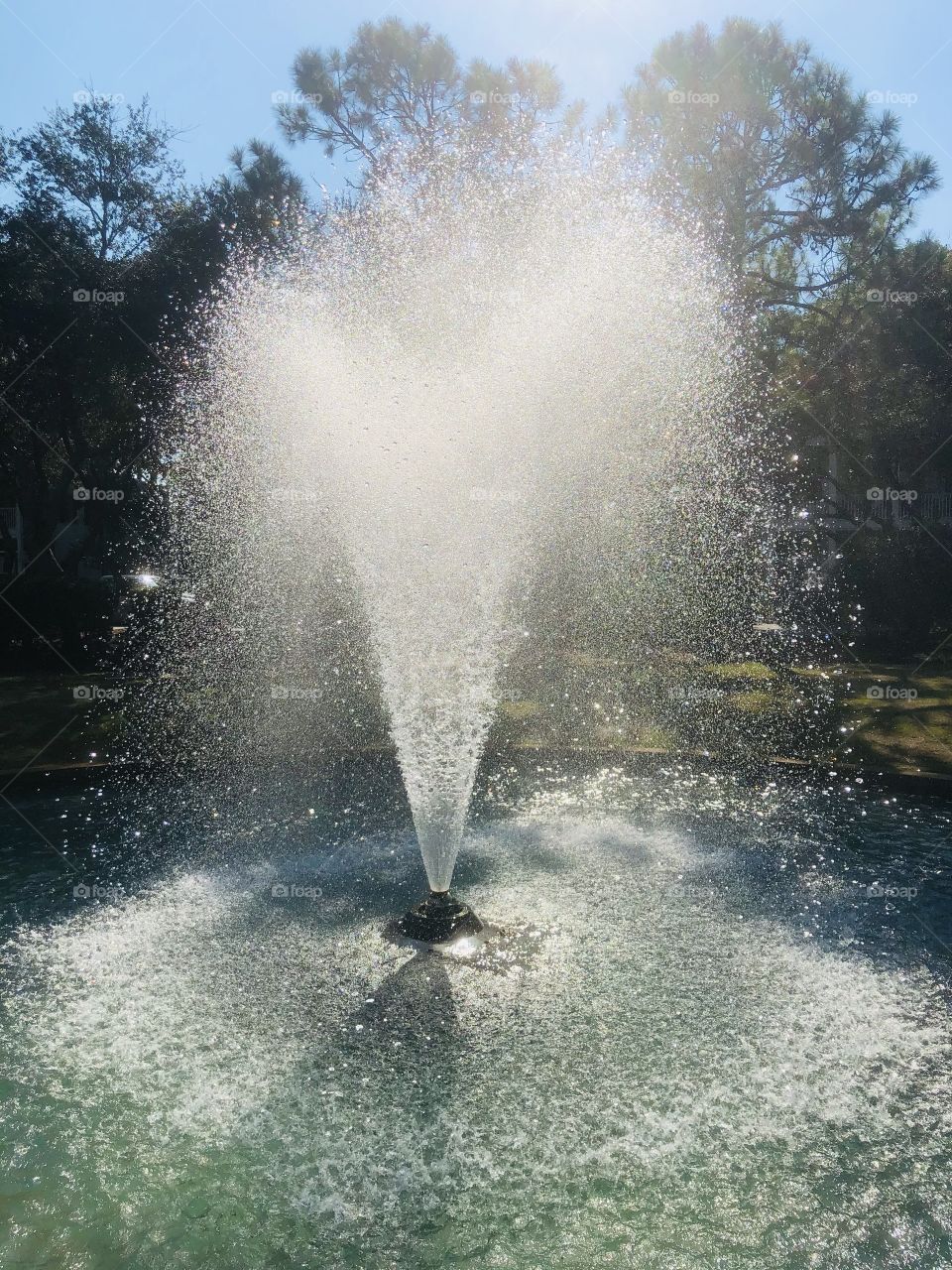 Sunlight and shadows on public fountain in garden 