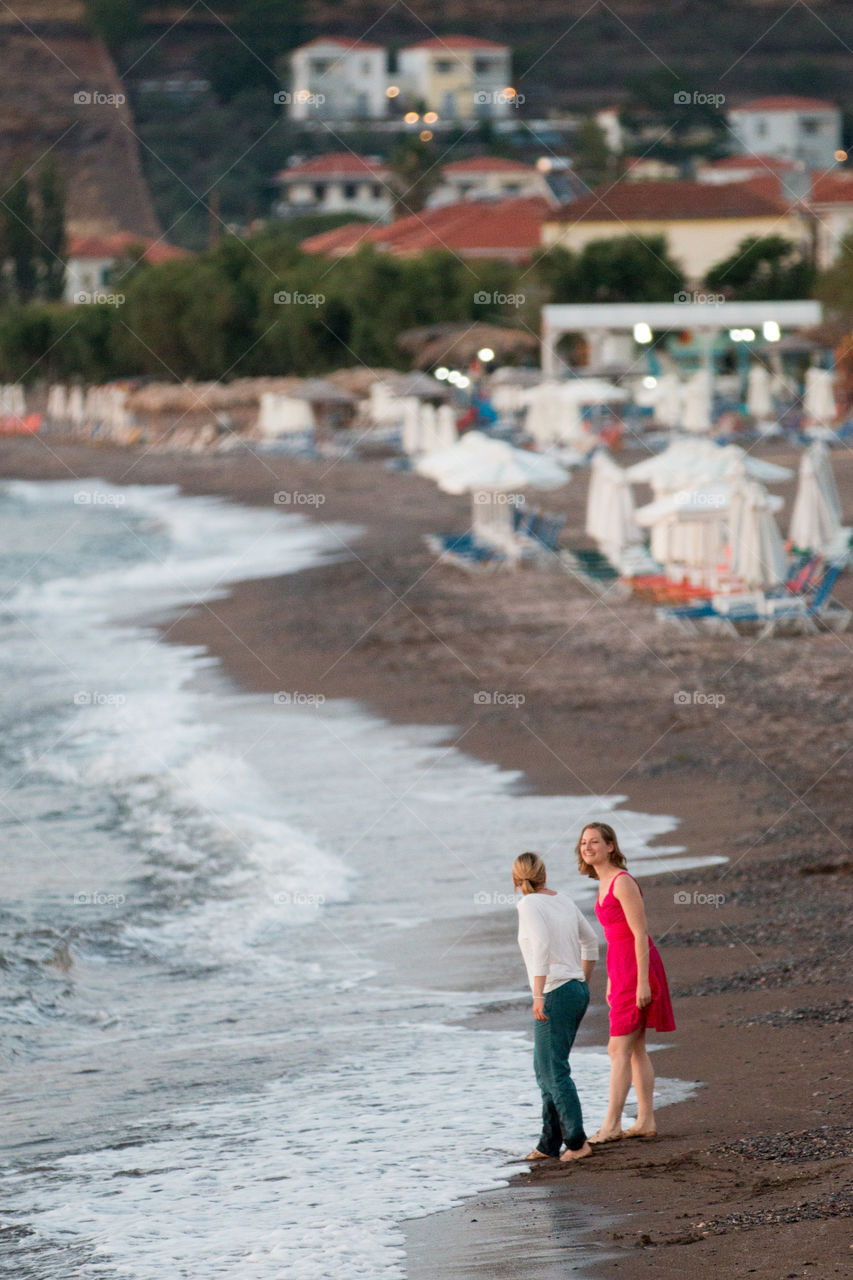 Two Women Friends Having Fun At The Beach
