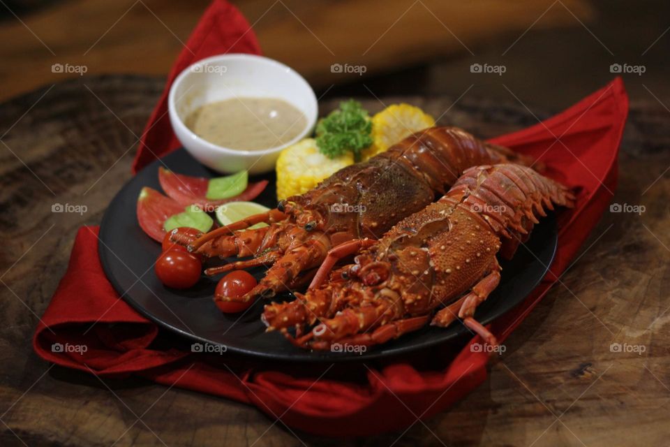 Lobster creamy garlic Lobster served with corn, tomatoes, lemon wedges, cherry and Asian-style creamy garlic sauce.