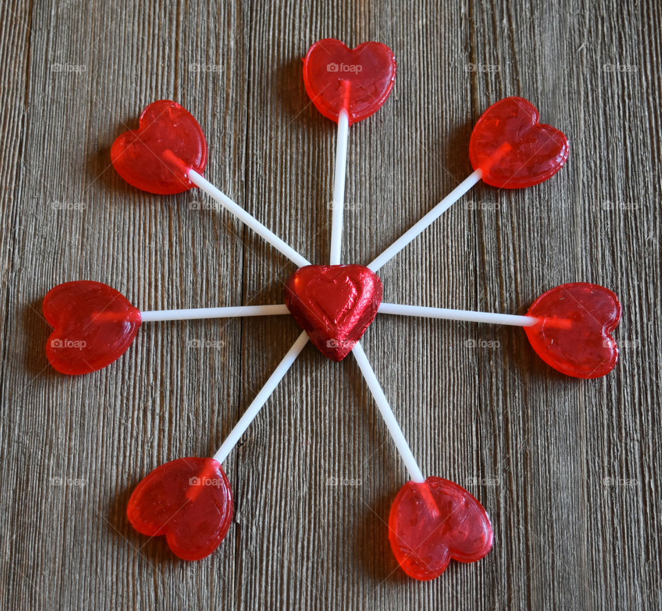 Heart shaped lollipops on a wood background