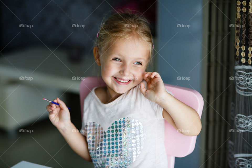 Candid portrait of happy little Caucasian girl with blonde hair 