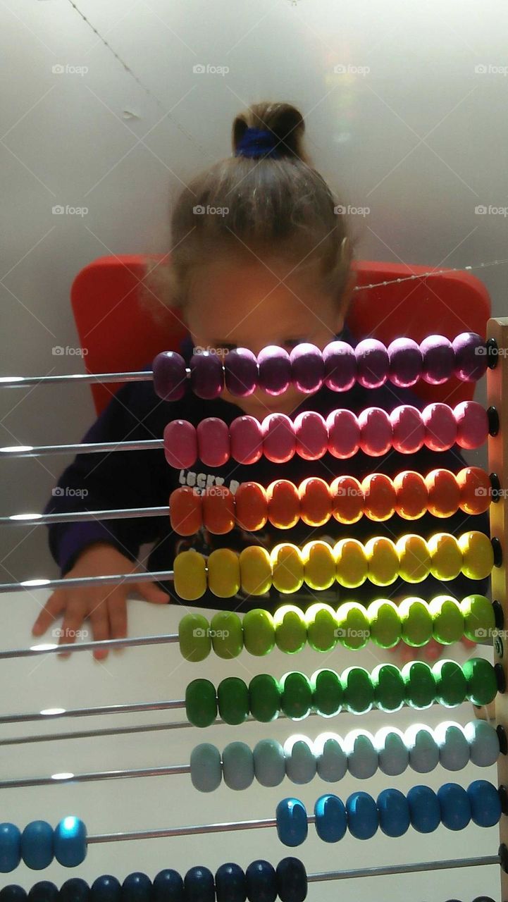 A child plays by Colored pellet setup.