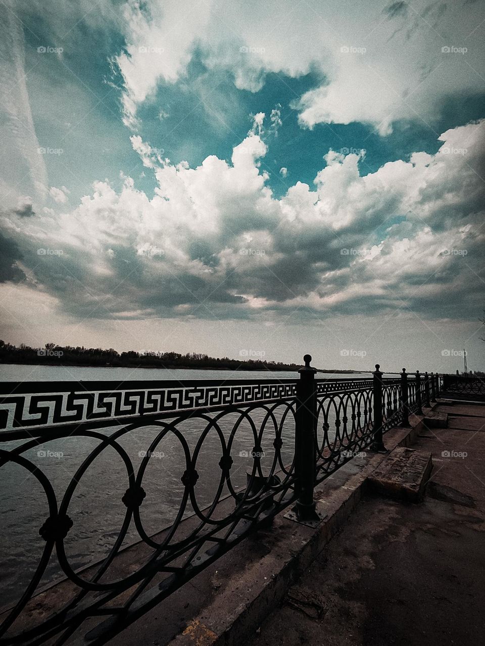 The embankment of the river against the background of clouds