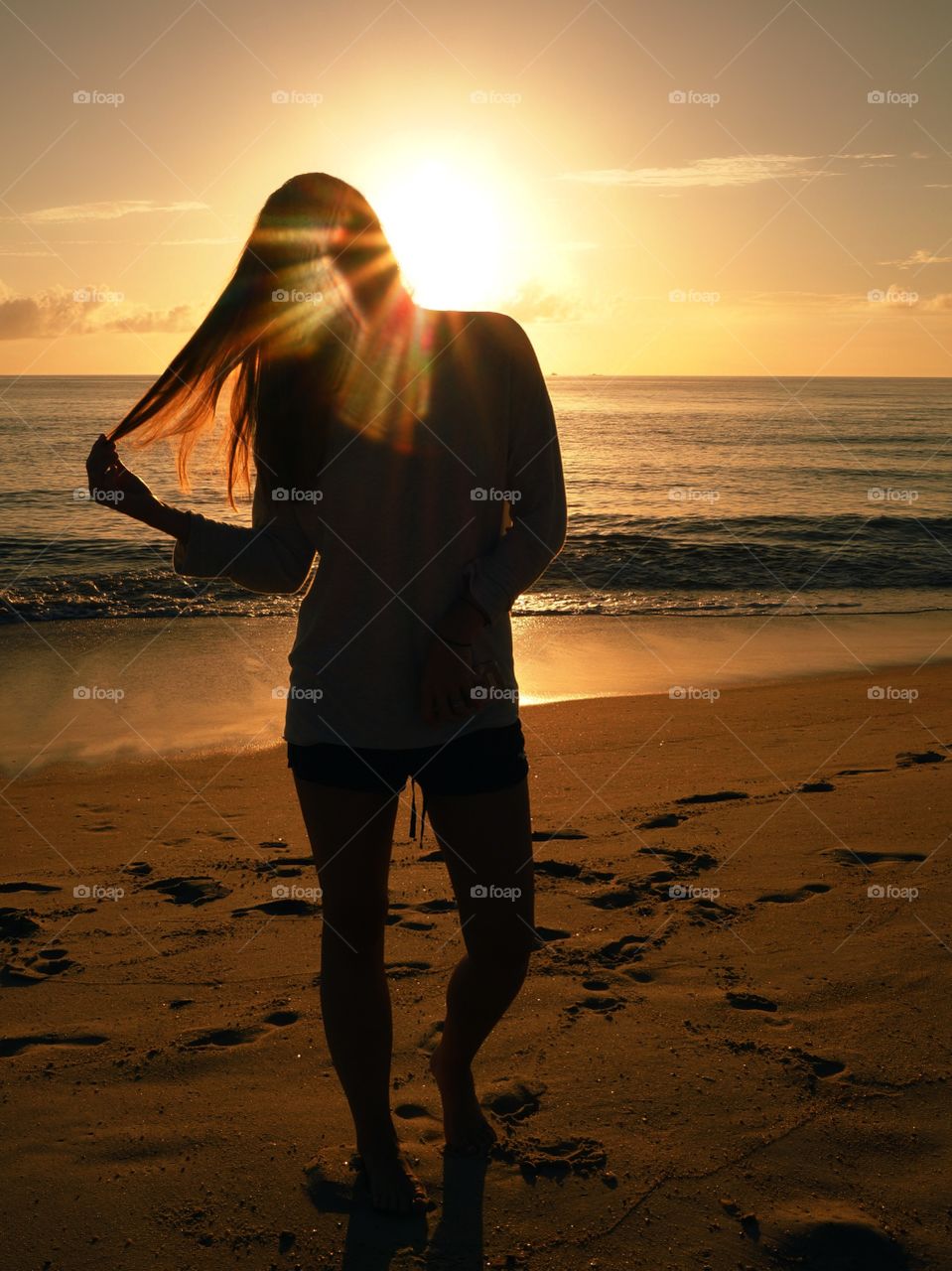Silhouette of woman standing near sandy beach