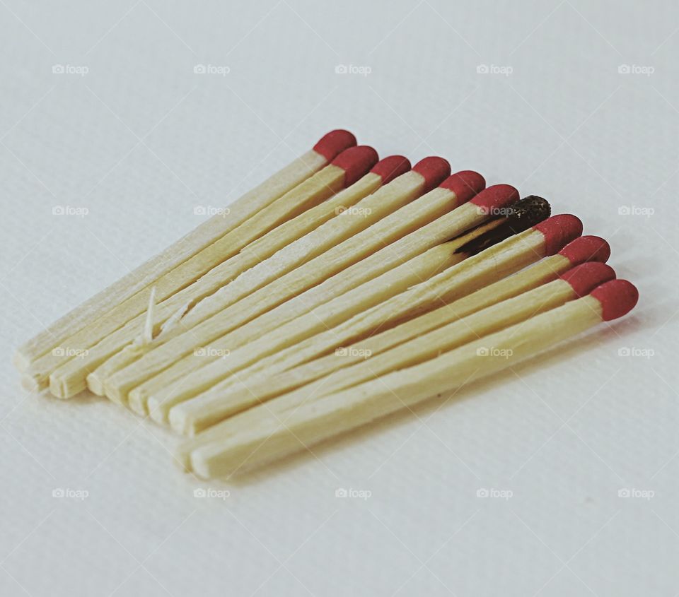 Odd one out - a burned matchstick in a group of good matchsticks 