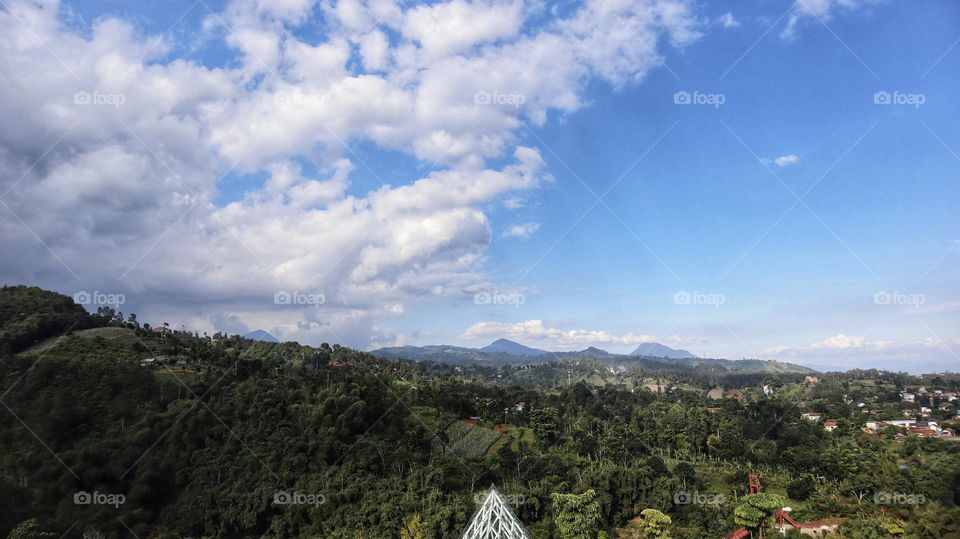 Landscape natural scenery of tropical mountains and residential residential areas with blue skies.