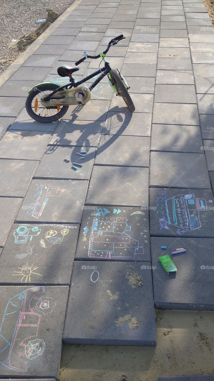 Summer games, a bike and kid's drawings on the street