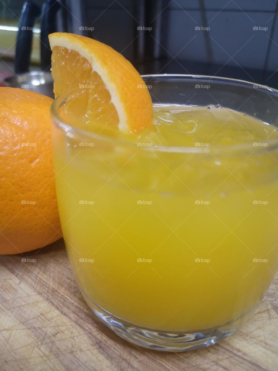 A glass of freshly squeezed orange juice with ice cubes