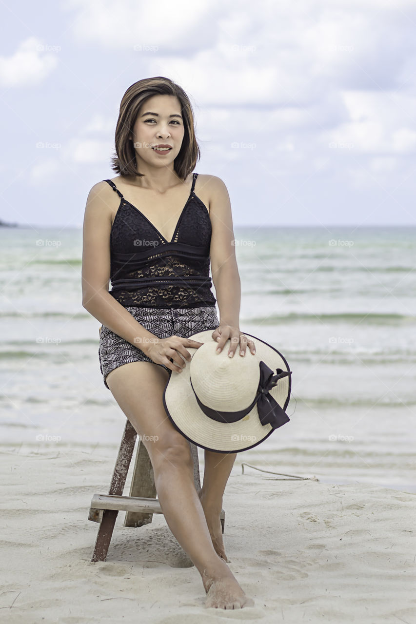 Portrait of Asian woman wearing a swimsuit background sea and sky