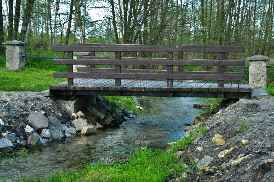 A source of clear water with bridge near the Chapel in the water in Krasnobród, Poland