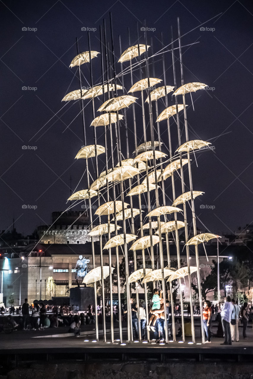 People Enjoying Night Out At Thessaloniki Famous Umbrellas Sculpture
