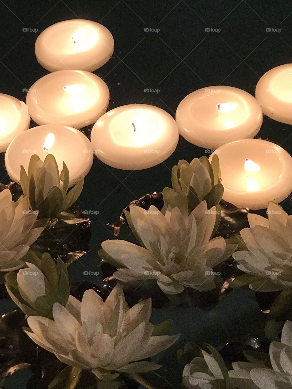 Floating water lilies and glowing candles 