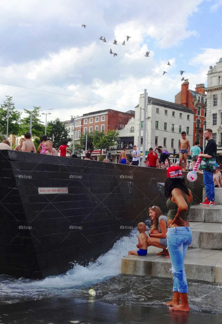 People cooling off in the fountains at Old Market Square in Nottingham, England