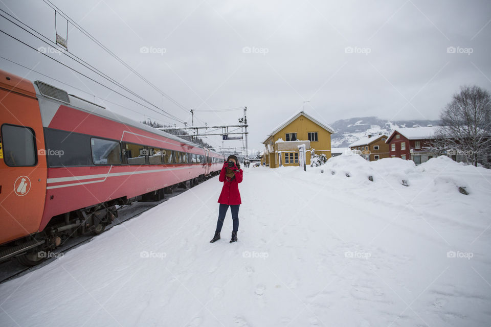 Girl taking a picture in a train station in Norway 