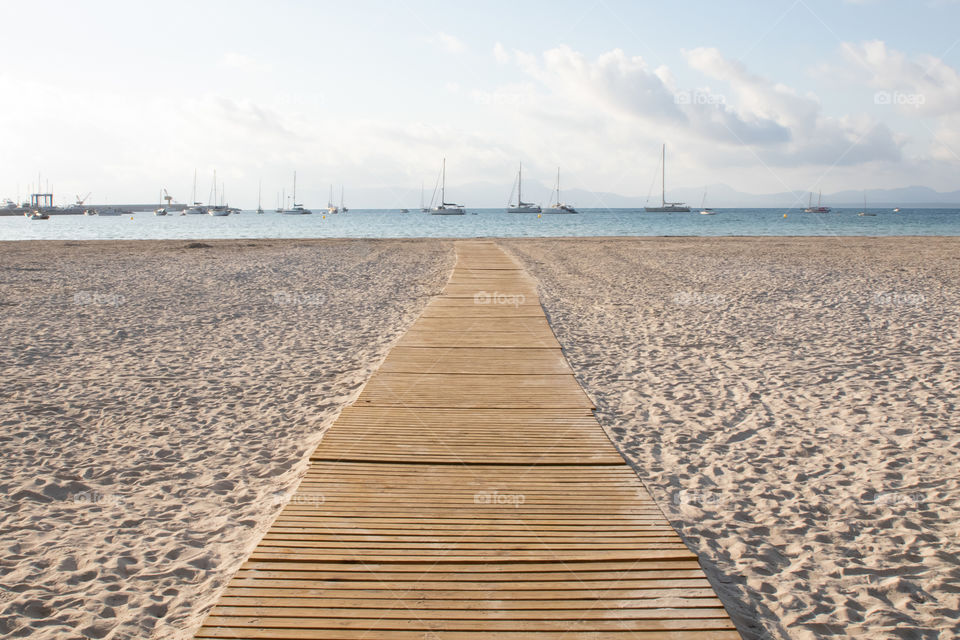 Early morning walk on wooden boardwalk on the beach in Alcudia Mallorca 
