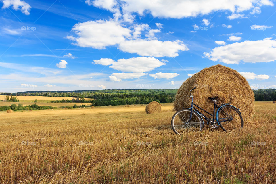 Bicycle in the field with big round bales of straw