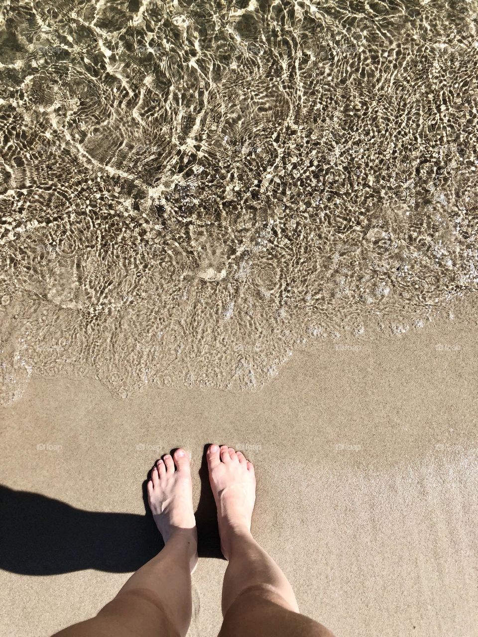 Overhead of feet meeting sea