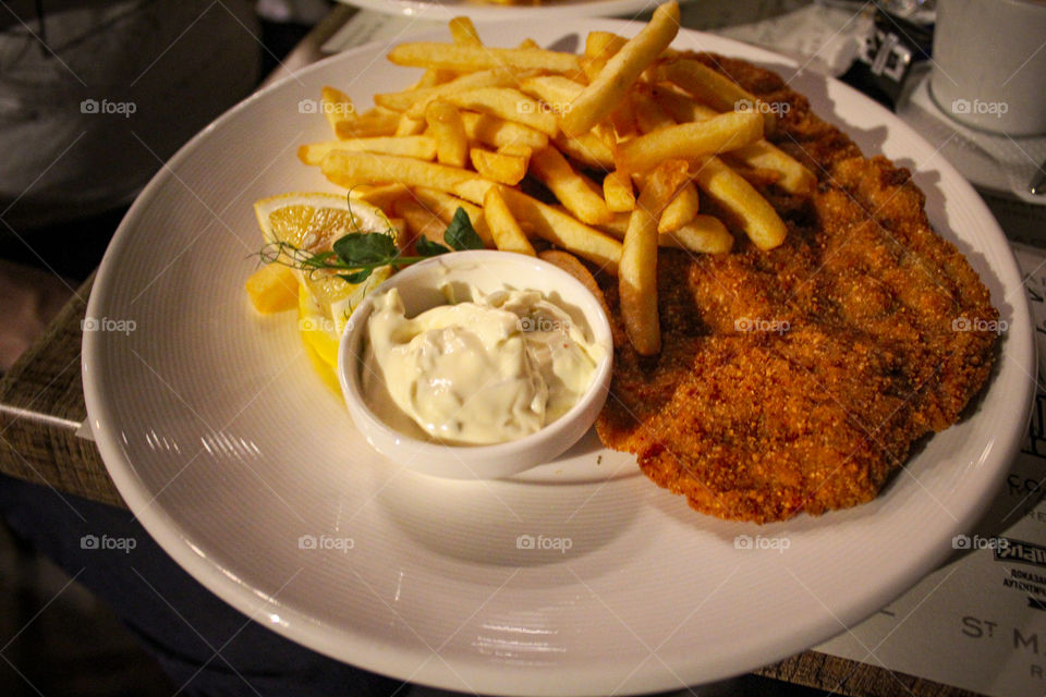 French fries, tartar sauce and becka steak at plate