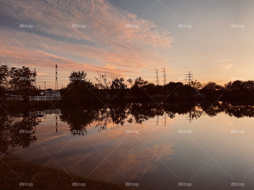 This unusual setting for Sunset not directly in the path of the setting sun but behind the scene. The colours and the Refections off the lake waters represents a Beautiful Setting.