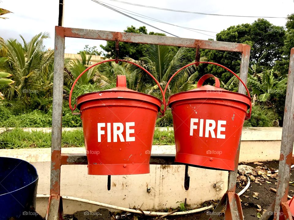 Red backets of water in case of fire at the gas station in Mauritius, Africa