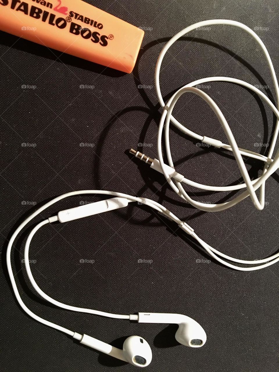 Earphones with heart shaped by shadow of wire