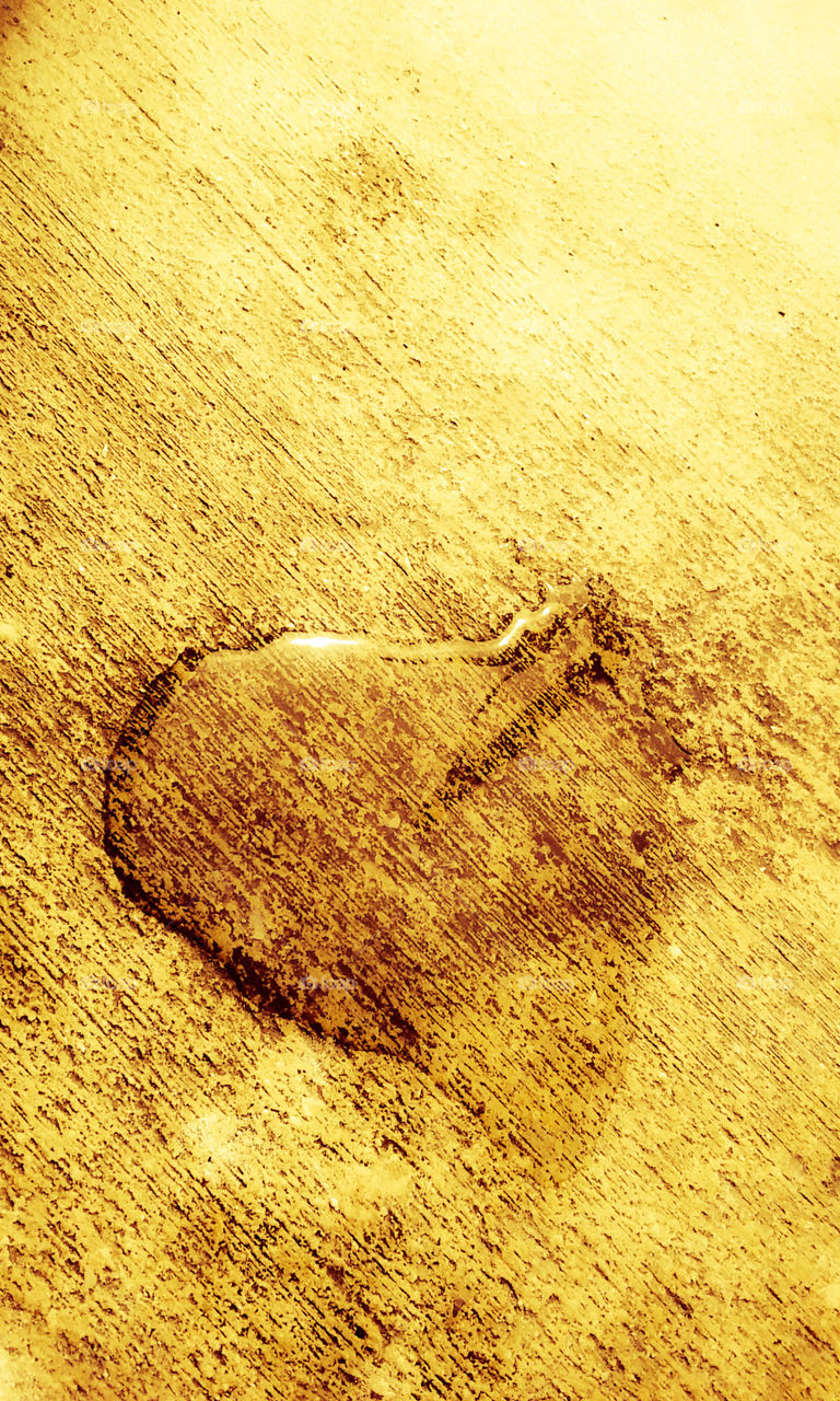 Heart shaped water drop on street pavement