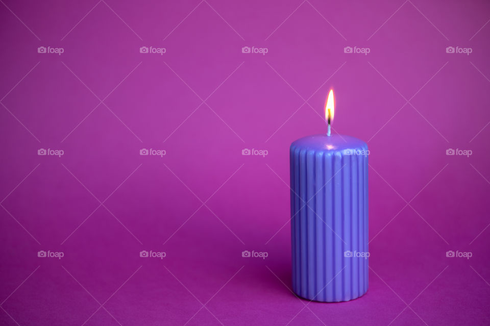 Purple candle on magnetas background