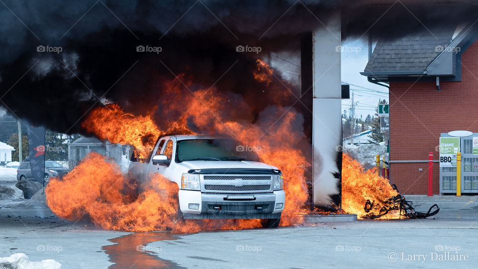 Burning truck and snowmobile at a gas station fire