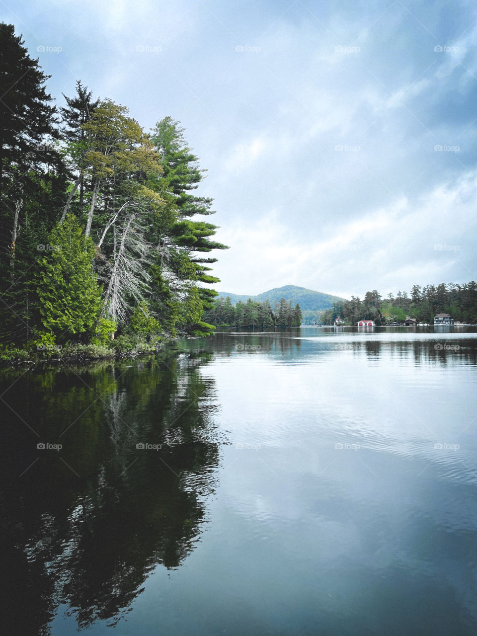 A cloudy day on lake placid with beautiful green trees.