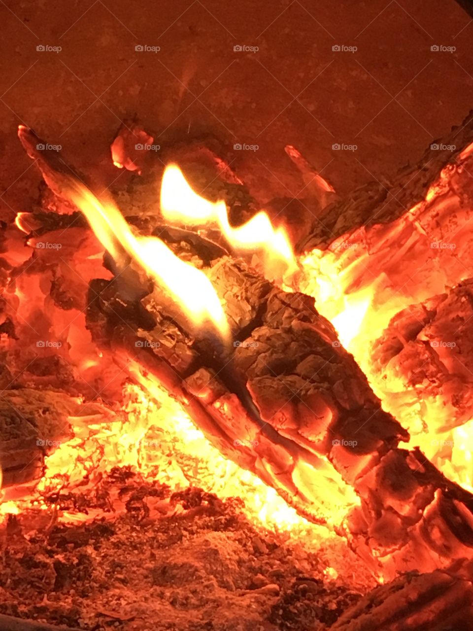 Flames as wooden logs burn on the fire in a chiminea in the garden 