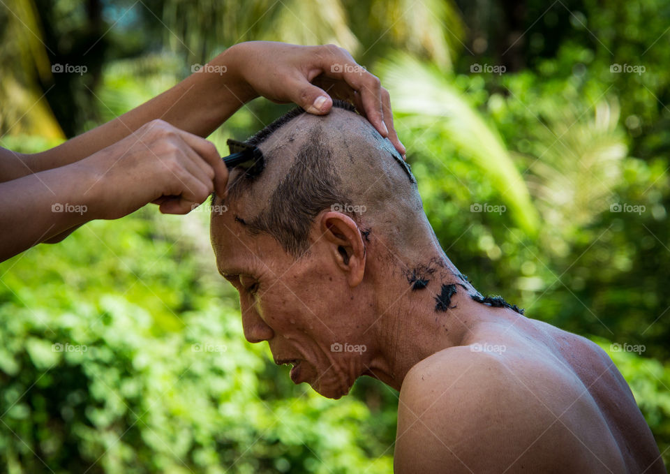 Monk getting his head shaved