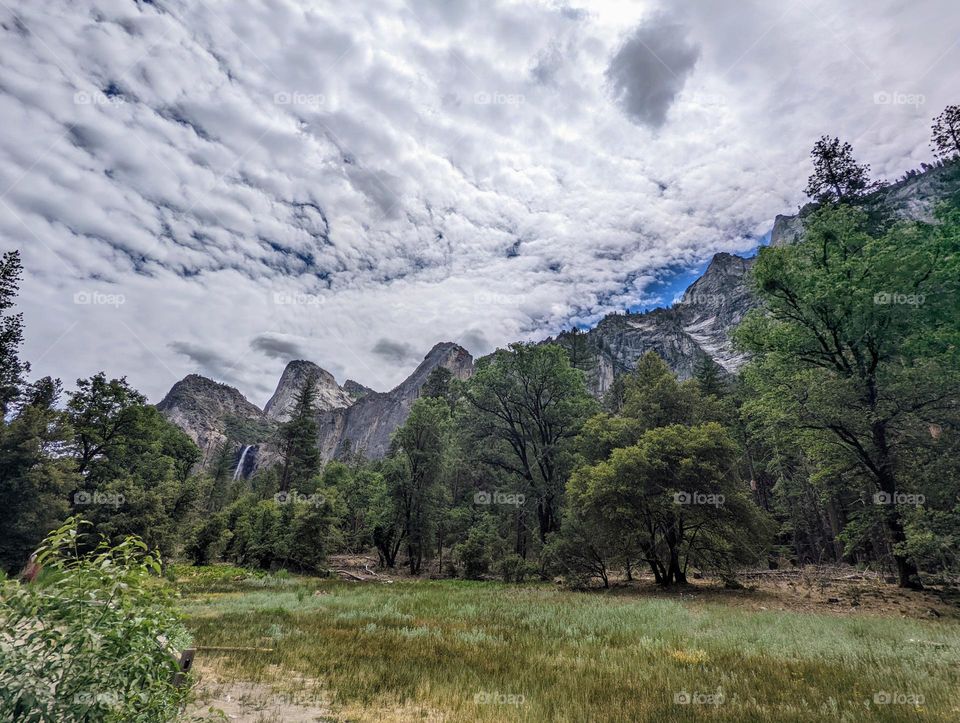 Waterfall and mountains with beautiful cloud patterns. A beautiful view in Yosemite Valley.