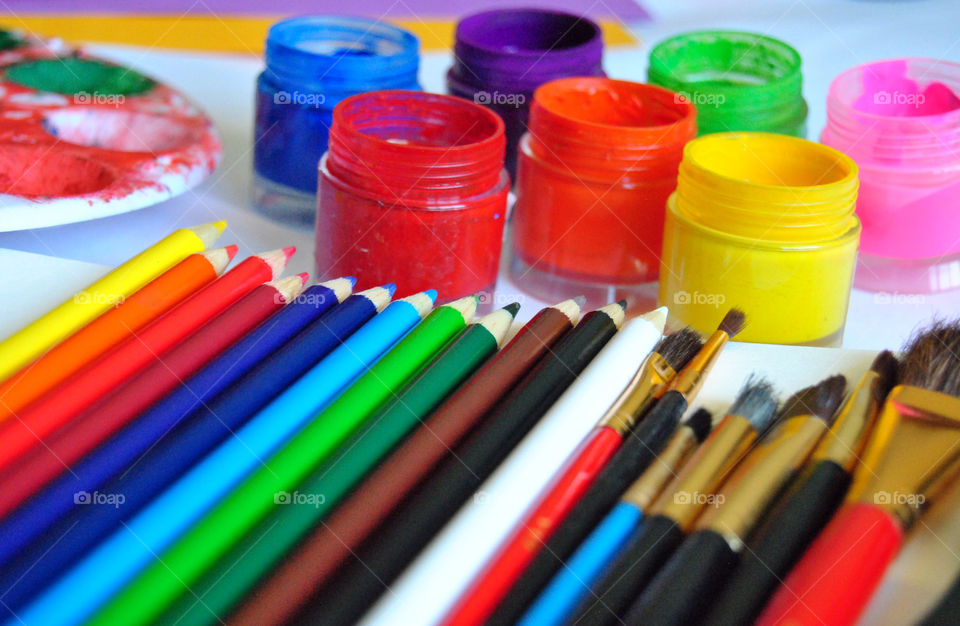 Art supplies, colored pencils, paintbrushes, paint, sketch book, watercolor pad, palette, paintbrush close-up