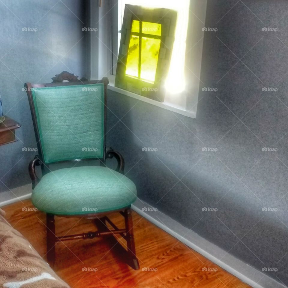 turquoise chair in bright corner with stained glass