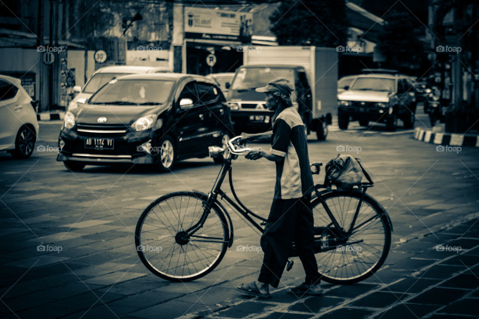 Seorang kakek yang sedang menyebrang menggunakan sepedanya di kawasan Tugu Yogyakarta