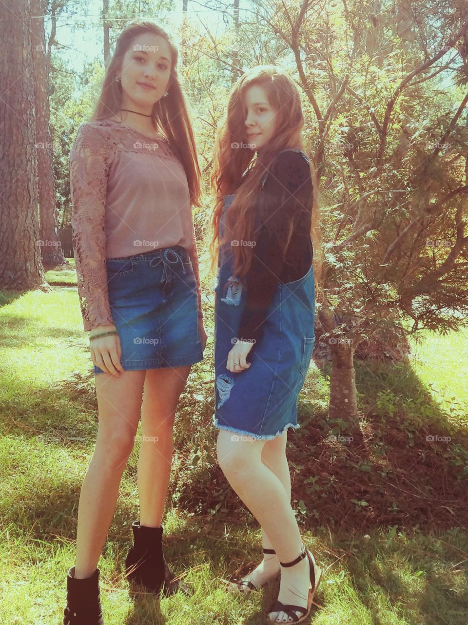 two beautiful girls outside in the trees during fall