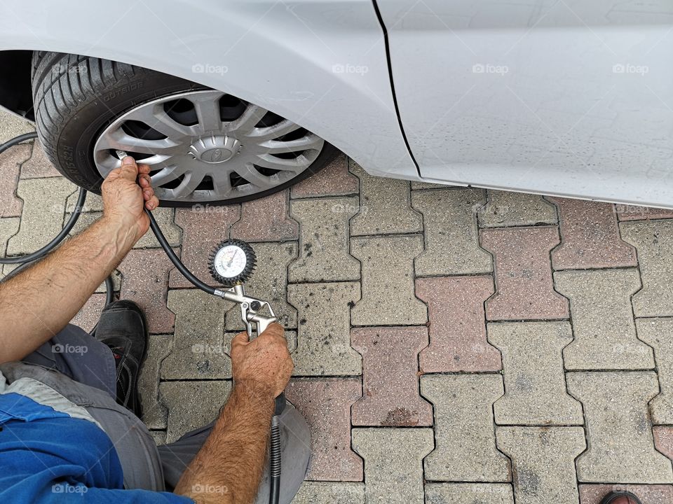 Mechanic measures tire pressure