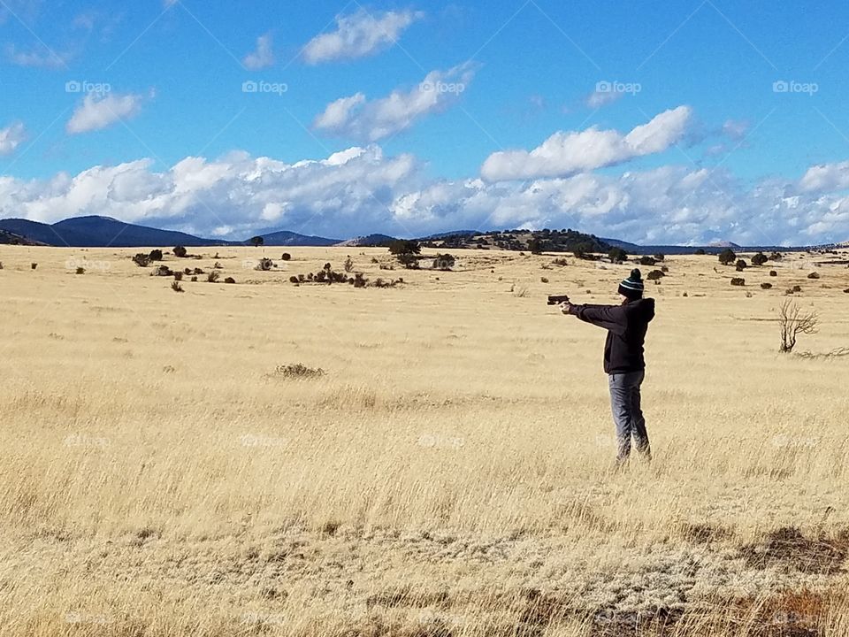 Target practice with a Sig Sauer p229 in a field in Arizona.