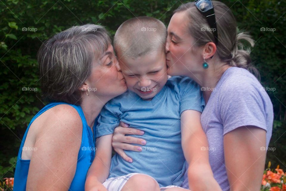 Covered in kisses. My mom (left), me (right) and my god son