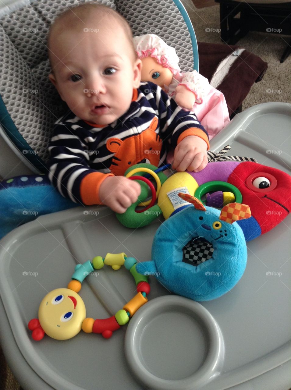 He still can't sit well by himself but with the support of his high chair or family he can play with toys while sitting :)