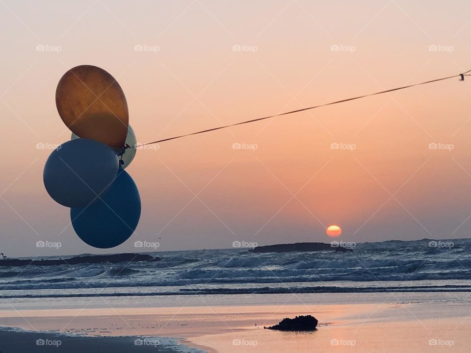 Beautiful multicolour balloons embracing golden sky at essaouira city in morocco 