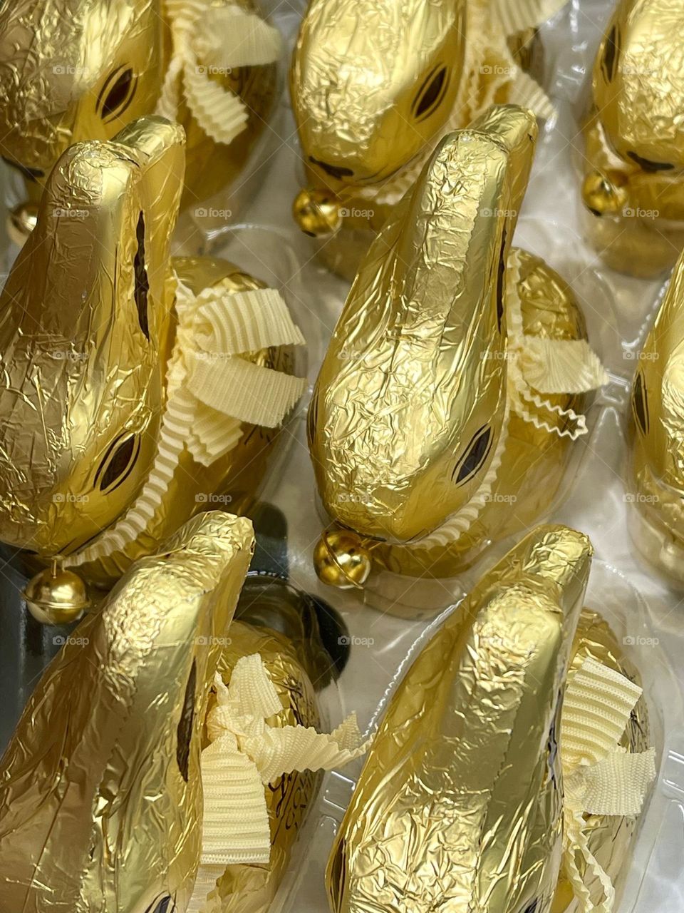 bunny-shaped chocolates wrapped in gold foil and decorated with a ribbon and a bell