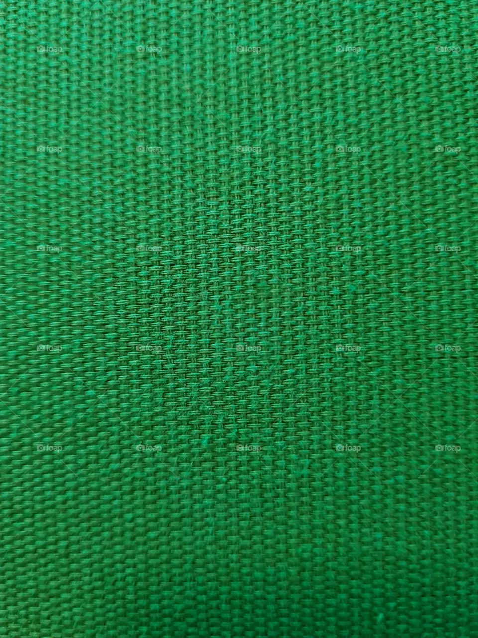 Bright green textile texture of a thick fabric seen from up close.