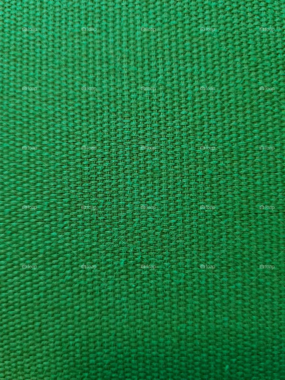 Bright green textile texture of a thick fabric seen from up close.