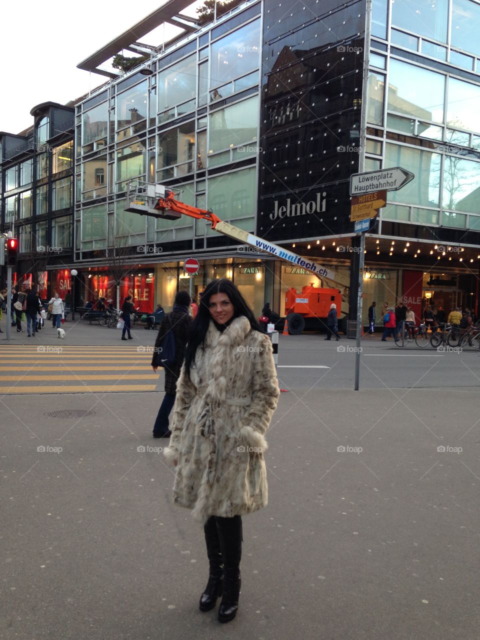 Girl in the fur coat in front of the building 